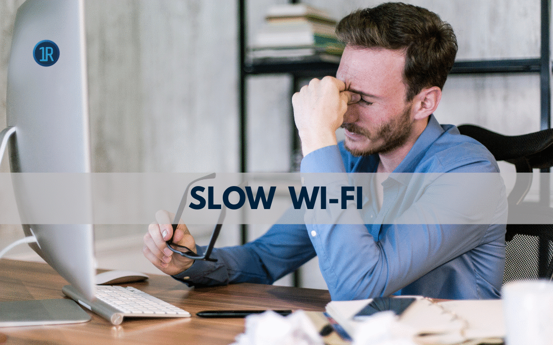Frustrated person sitting at computer desk looking worried while experiencing slow wi-fi and internet connection problems